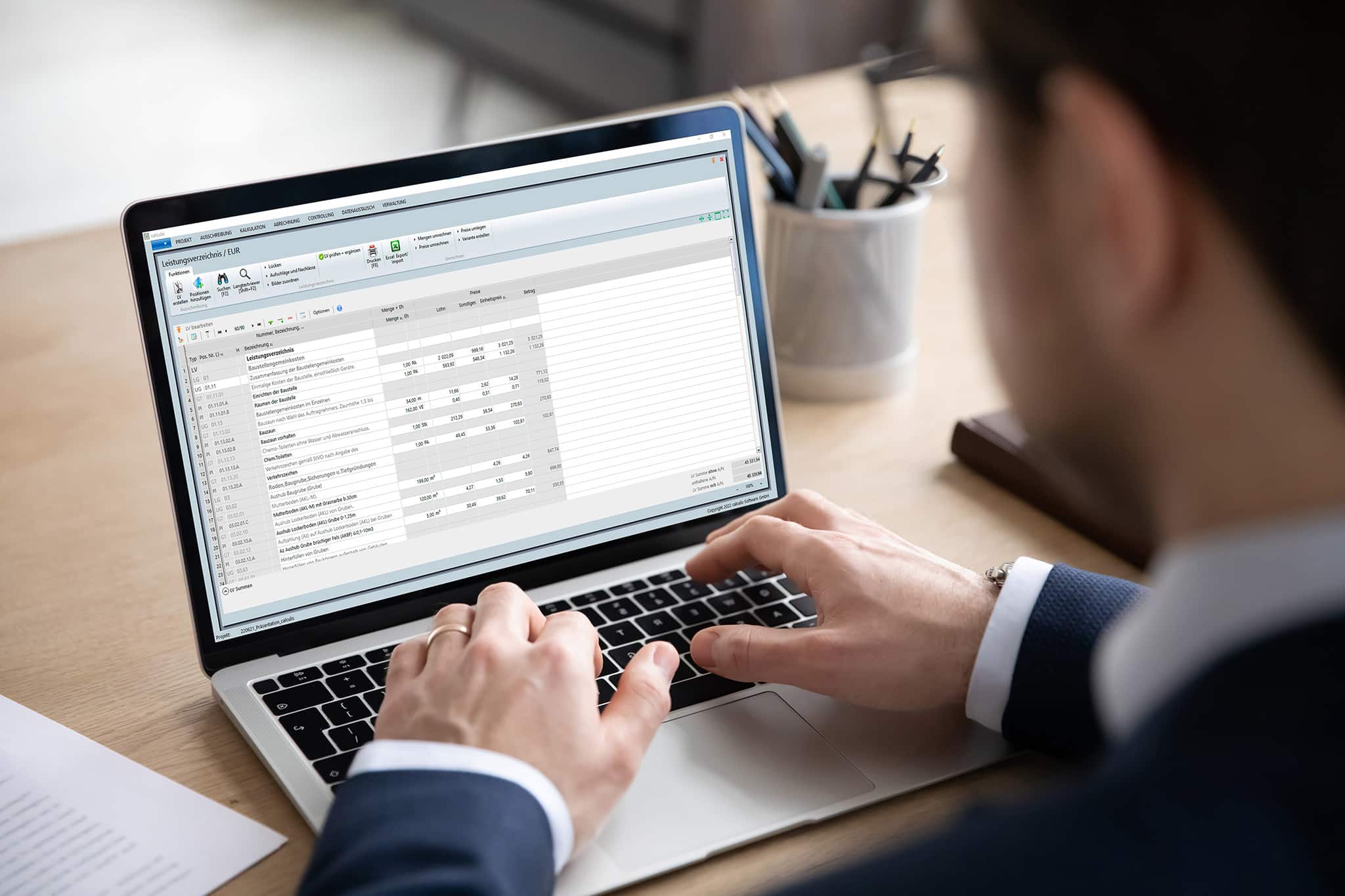 Person arbeitet am Laptop mit calculis Software